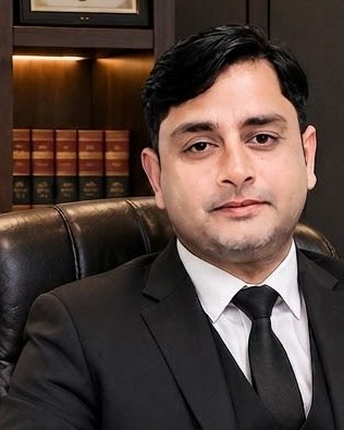 Portrait of Shakeel Ahmed Khanzada, manager of Khanzada Metals and Alloys, wearing a dark suit and tie.